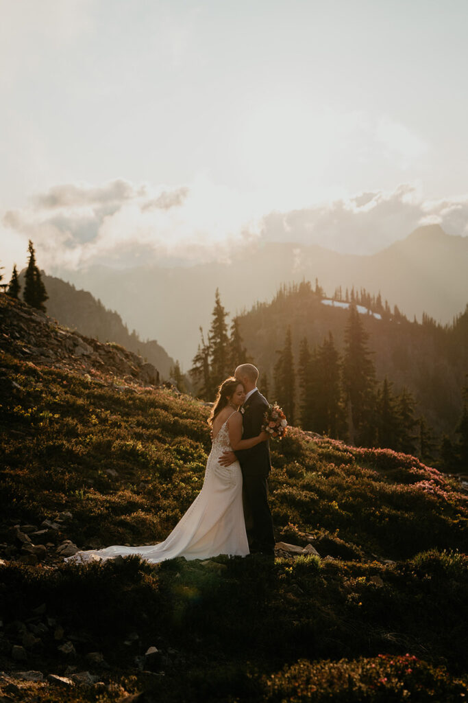 A couple kissing at sunset with Mt Rainier in the background. 