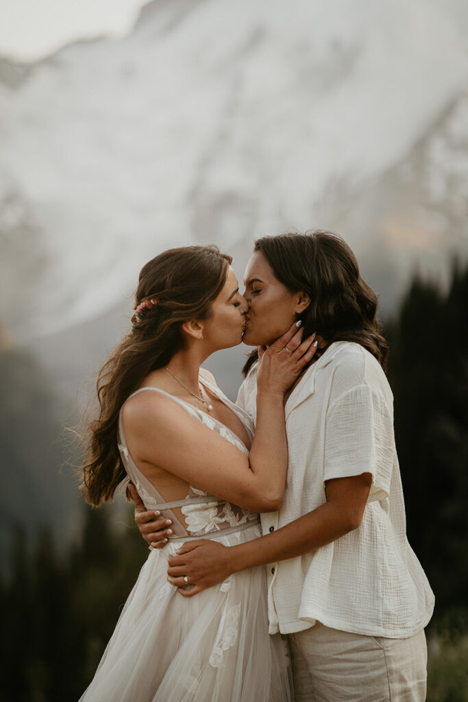 Newlyweds kissing with Mt Rainier in the background.