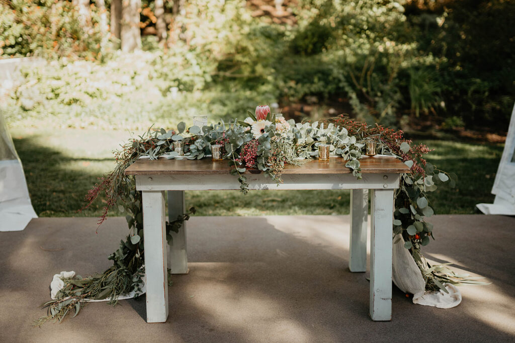 flowers and greenery on a table. 