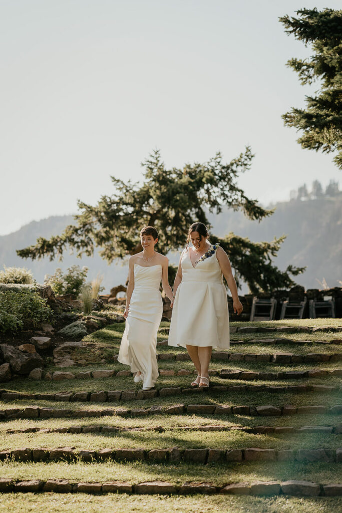 A couple holding hands and walking down stone steps. 