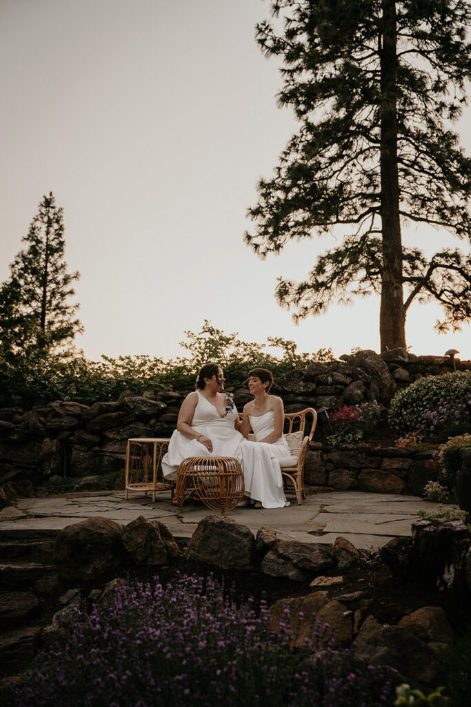 a couple sitting on an outdoor bench at sunset. 