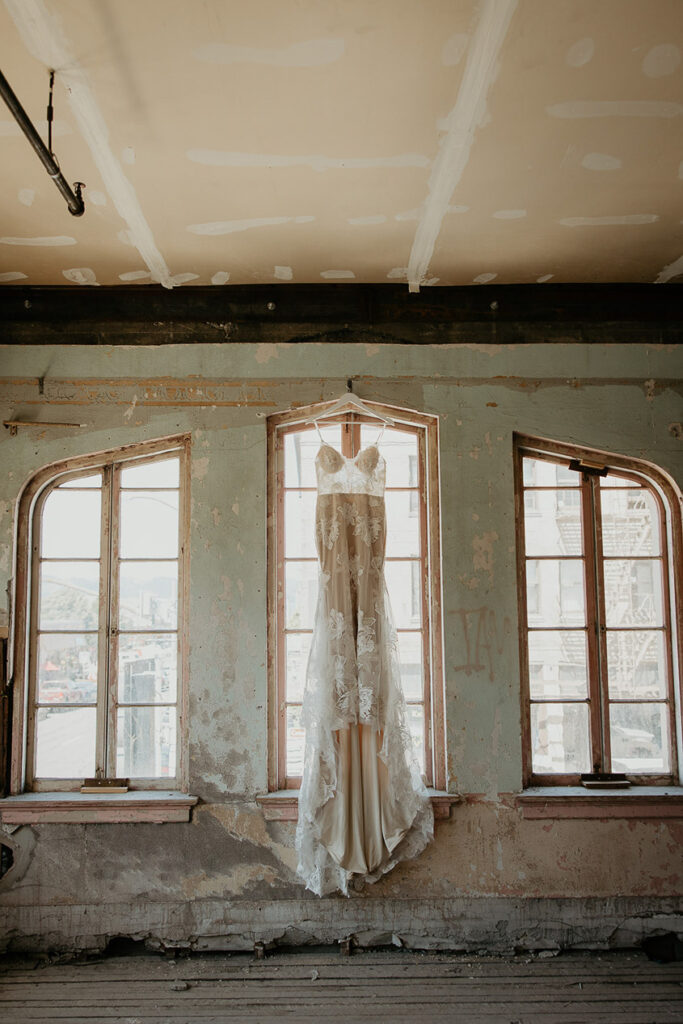 A wedding dress hanging from a window at The Ruins at the Astor. 