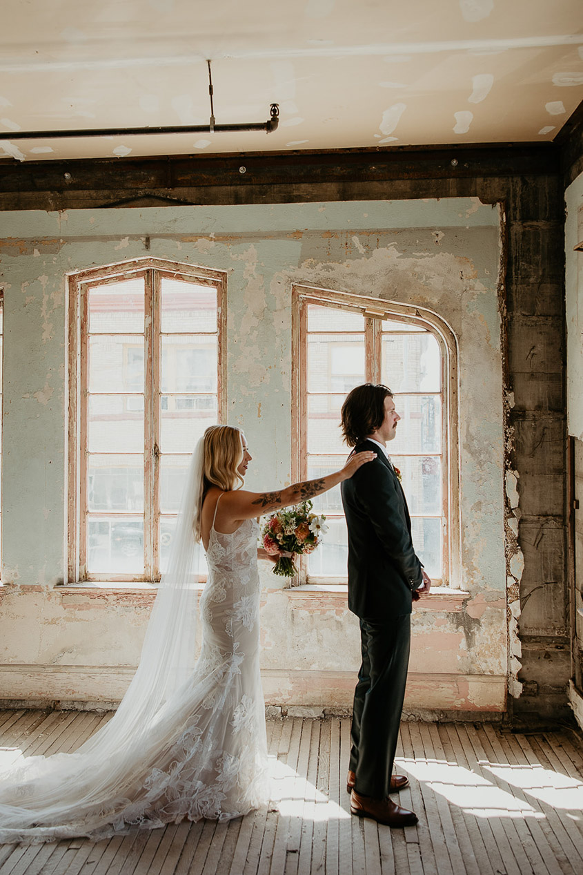 The bride touching the groom on the shoulder right before the first look at The Ruins at the Astor.