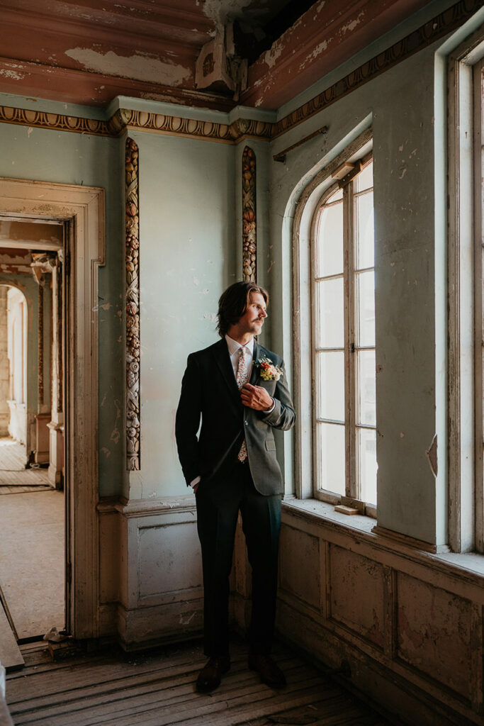 the groom looking out of a window at The Ruins at the Astor. 