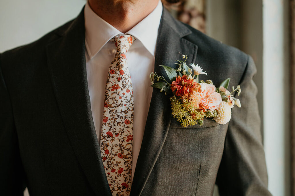 A close up of the groom's coat pocket filled with flowers. 