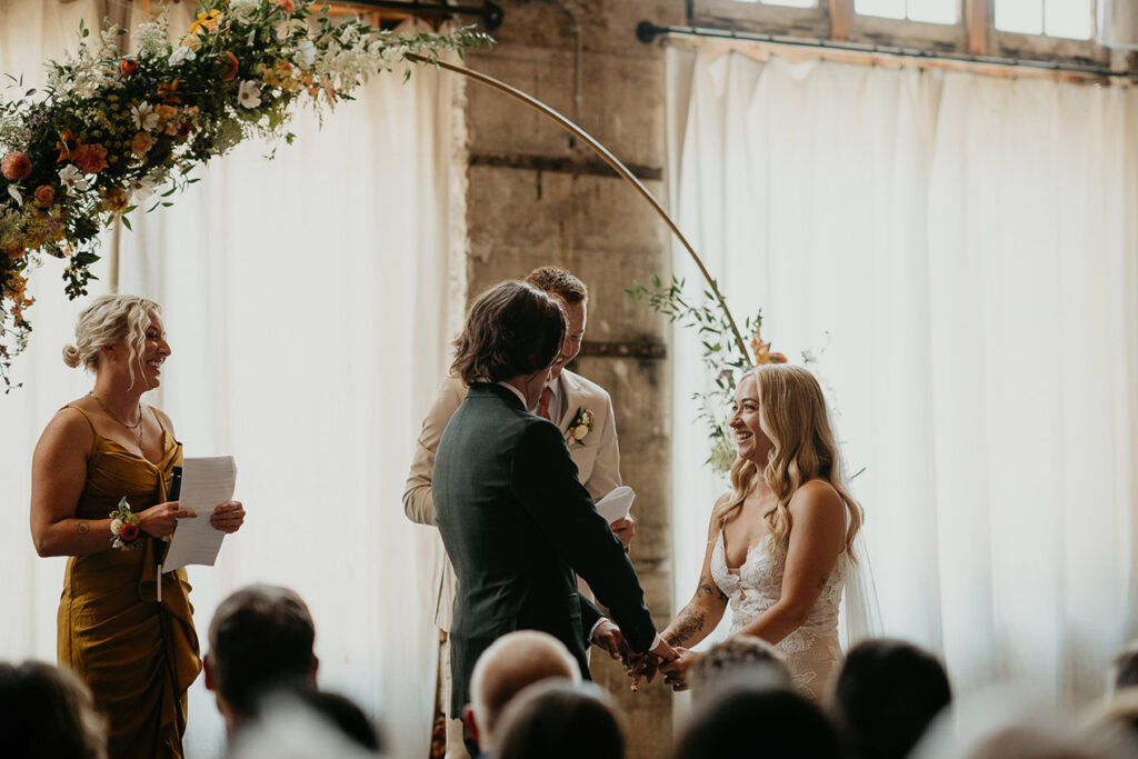 The bride and groom holding hands at the alter. 