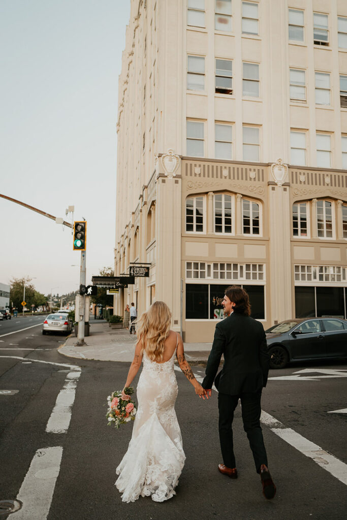 the newlyweds crossing the street and holding hands. 