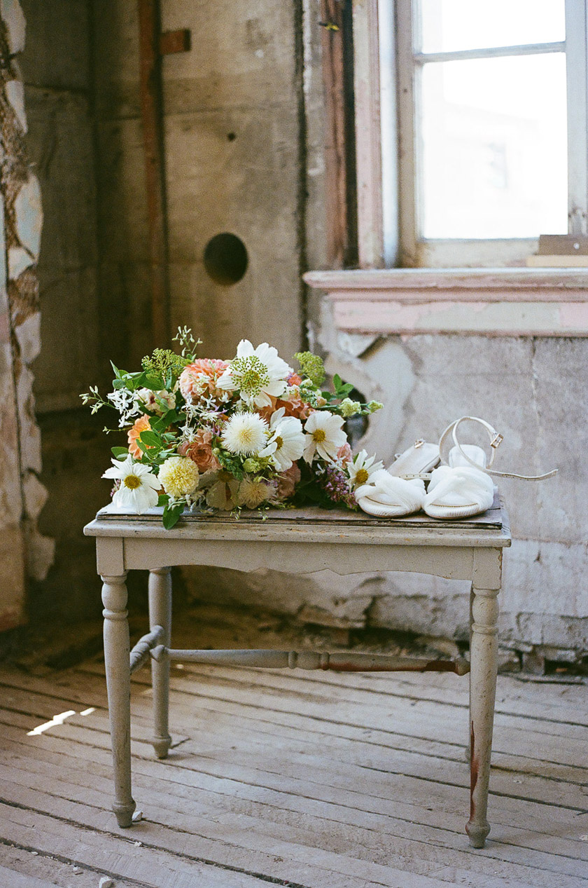 A bench with flowers and heals on top of it. 