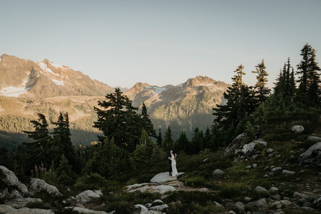 Bride and groom stand on a mountain trail while they elope in the North Cascades