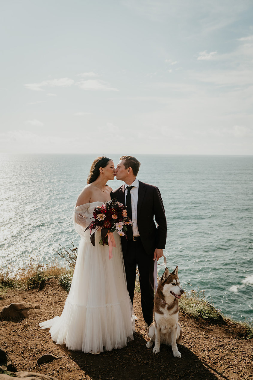 A couple kissing during their Oregon Coast elopement with their dog. 