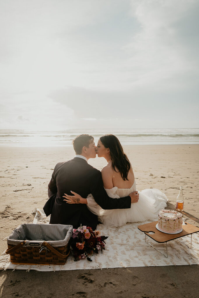 The newlyweds kissing during a picnic on the Oregon Coast. 