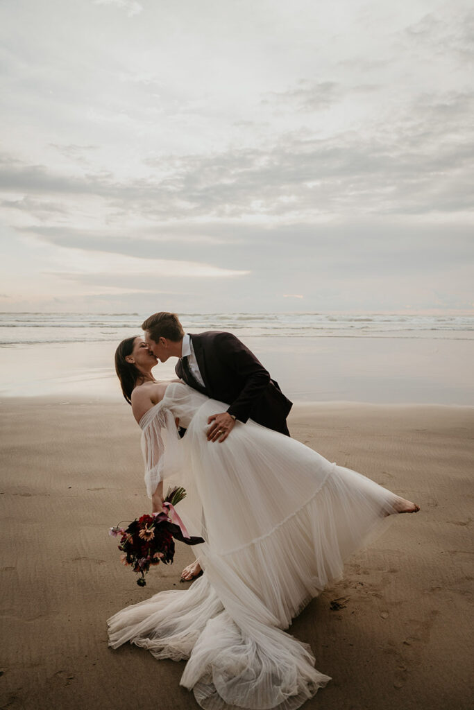 the newlyweds kissing on the beach.