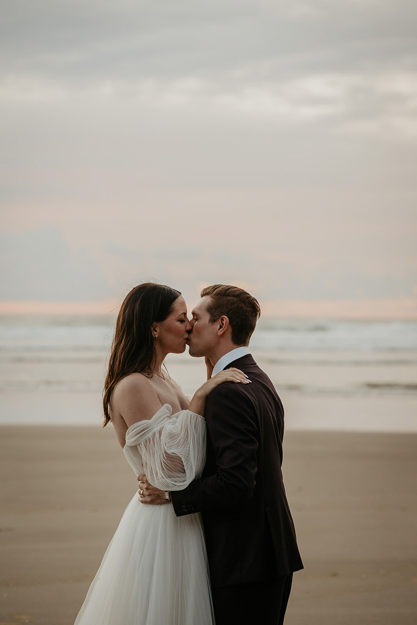 the newlyweds kissing during their Oregon Coast elopement on the beach. 